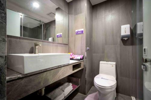 a bathroom with a sink and a toilet at OUGE Motel - Fengshan in Kaohsiung