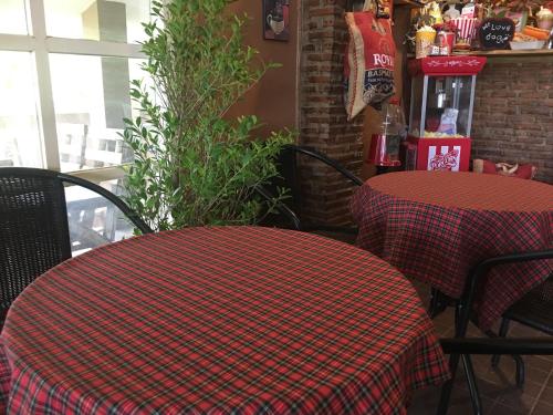 two tables in a restaurant with a plaid table cloth on them at The Green land (Khok Kruat) in Nakhon Ratchasima
