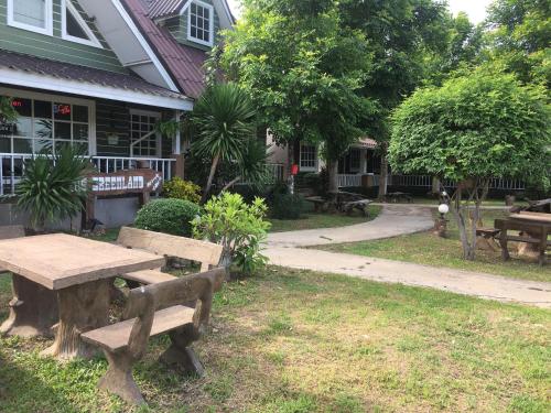 a wooden picnic table in front of a house at The Green land (Khok Kruat) in Nakhon Ratchasima