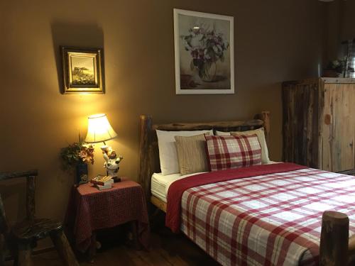 a bedroom with a bed and a table with a lamp at The Green land (Khok Kruat) in Nakhon Ratchasima
