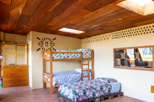 1 dormitorio con 2 literas y ventana en Casa 100% ecológica con vista a los glaciares andinos en Maras