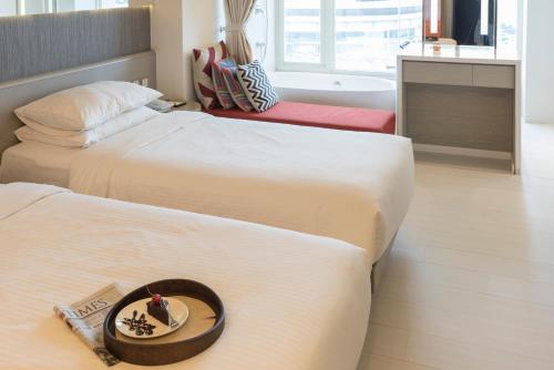 two beds in a hotel room with a plate of food at Inhouse Hotel Yehliu in Wanli