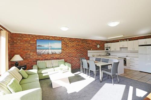 a living room and kitchen with a couch and a table at Pelican Waters in Merimbula