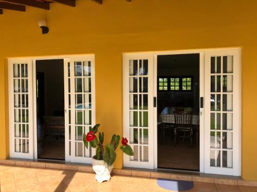 a house with french doors and a vase with a plant at Chácara Verzani in Socorro