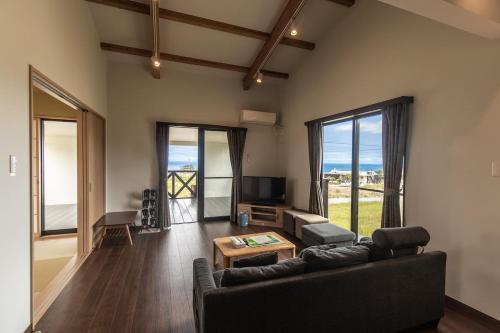 a living room with a couch and a table at Tabi no Yado in Nakijin