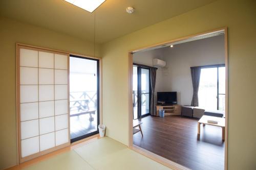 a living room with a large sliding glass door at Tabi no Yado in Nakijin
