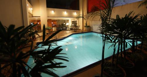 a large swimming pool in a building with plants at Convair Hotel in Ciudad del Este