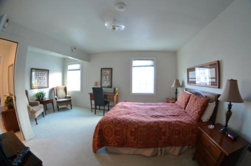 a bedroom with a large bed and a living room at Colony Inn in Palmer