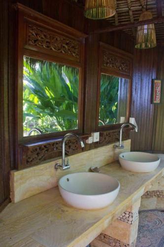 a bathroom with two sinks and two windows at Jasri Dalem Surf Retreat in Jasri