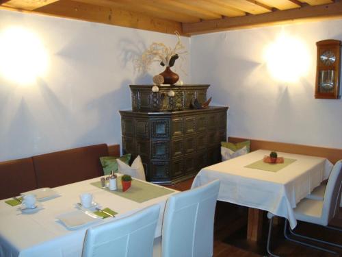 a dining room with two tables and a cabinet at Haus Hinterfürbach in Wagrain