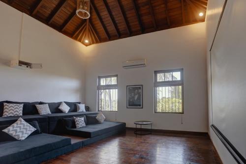 a living room with a blue couch and two windows at The Postcard Galle in Galle