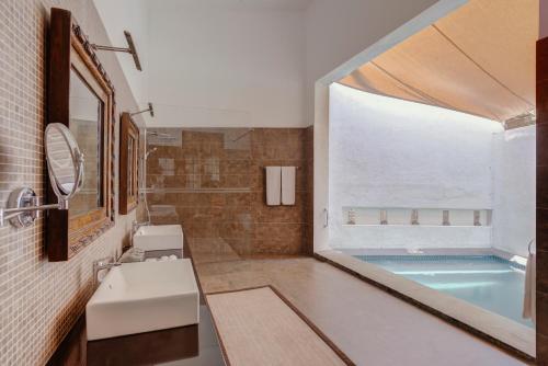 a bathroom with a sink and a swimming pool at The Postcard Galle in Galle