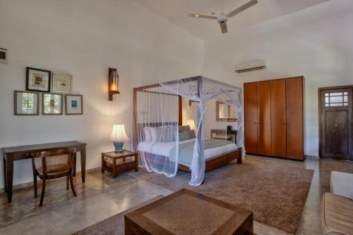a bedroom with a bed with a canopy at The Postcard Galle in Galle