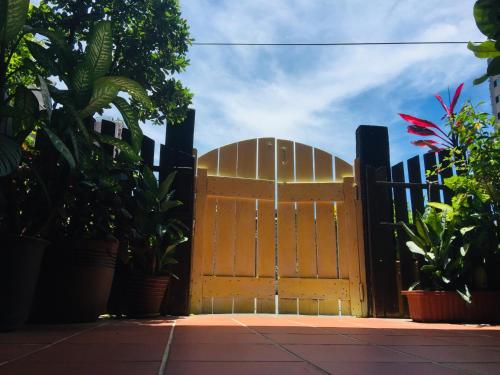 a wooden gate in front of a fence with plants at Mamamia Homestay in Hengchun