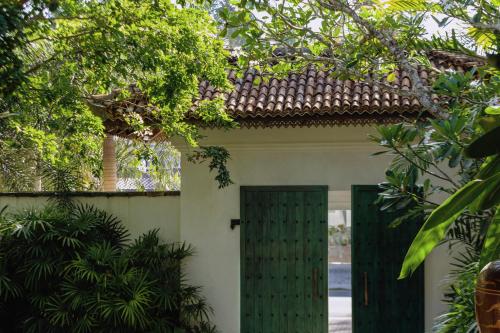 a house with a green door and trees at The Postcard Galle in Galle