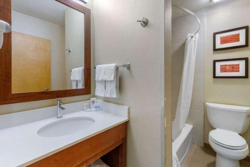 a bathroom with a sink and a toilet and a mirror at Comfort Inn Trolley Square in Rutland