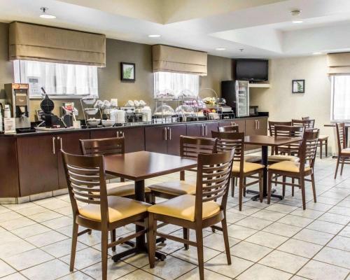 a restaurant with tables and chairs and a kitchen at Sleep Inn Richmond North in Richmond