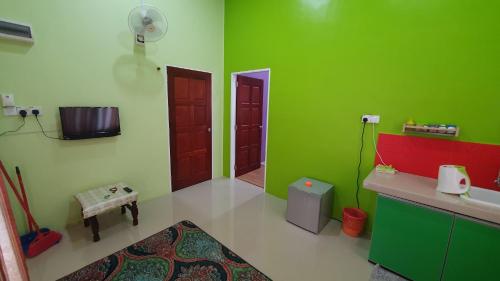 Camera verde con lavandino e specchio di 3H REST HOUSE @ HOMESTAY a Kuala Terengganu
