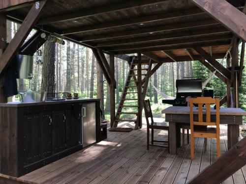 a screened in porch with a stove and a table at Tahkuna tree-house in Malvaste