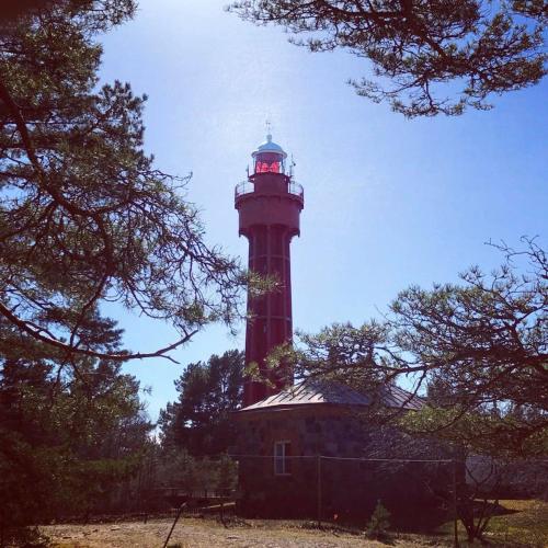 a lighthouse with a red light on top of it at Tahkuna tree-house in Malvaste