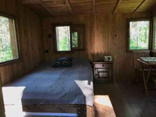 a bedroom with a bed in a wooden cabin at Tahkuna tree-house in Malvaste