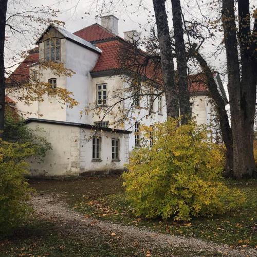 a large white house with a red roof at Tahkuna tree-house in Malvaste