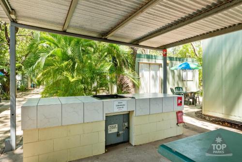 an outdoor kitchen in a patio with a roof at Riverview Tourist Village in Katherine