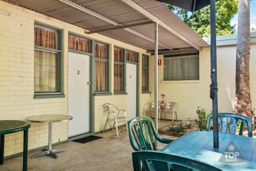 a patio with a table and chairs and a door at Riverview Tourist Village in Katherine