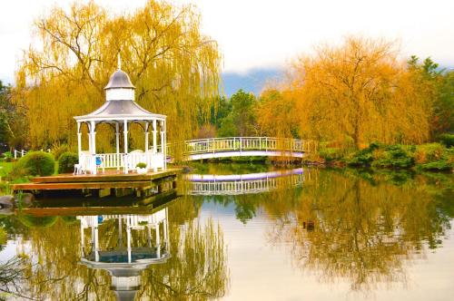 a gazebo in the middle of a lake with a bridge at Lakeside Cottage Luxury B&B in Mount Dandenong