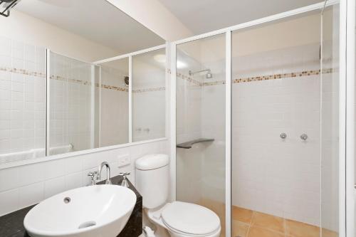 a bathroom with a toilet and a sink and a shower at Byron Getaway @the Crest in Byron Bay
