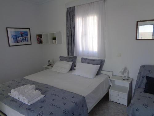 a small bedroom with a bed and a window at Blue and White Studios & Apartments in Lefkos Karpathou