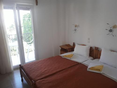 a bedroom with a large bed and a window at Pension Nikolas in Skiathos