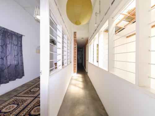 a hallway with white walls and a rug at Bata Merah Boutique Hotel in Banting