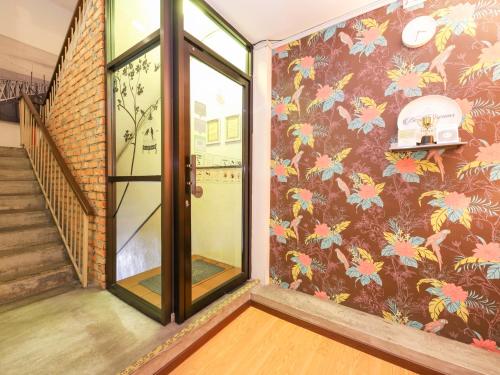 a hallway with a mural of flowers on a wall at Bata Merah Boutique Hotel in Banting