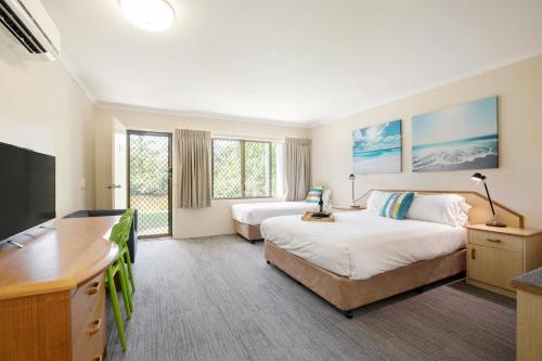 ハービーベイにあるKondari Hotelのベッド2台、薄型テレビが備わるホテルルームです。