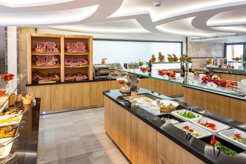 a buffet line in a restaurant with a lot of food at Rhodos Horizon City-Adults Only in Rhodes Town