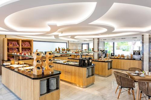 a restaurant with a buffet line with tables and chairs at Rhodos Horizon City-Adults Only in Rhodes Town