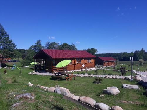 a log cabin with a green roof in a field at chalets les 5 loups in Gerbépal