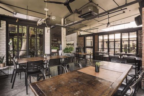 an empty restaurant with wooden tables and chairs at The Flying Fish Hostel in Dumaguete