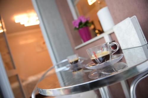 una mesa de cristal con dos tazas de café. en DERELLI Deluxe and DERELLI Adorable apartments, en Sofía