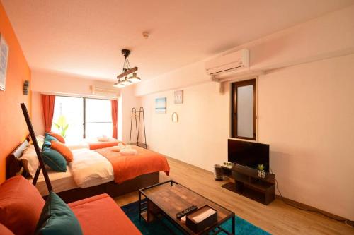 a room with two beds and a tv and a couch at Roppongi Azabu Sunshine Resort House in Tokyo