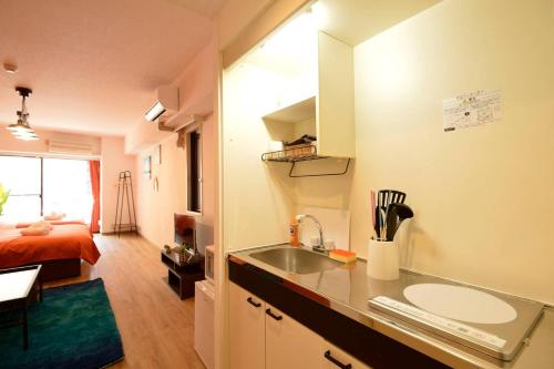a kitchen with a sink and a room with a bed at Roppongi Azabu Sunshine Resort House in Tokyo