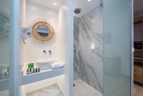 W łazience znajduje się umywalka i lustro. w obiekcie Solimar Turquoise - Adults Only w mieście Agia Marina Nea Kydonias