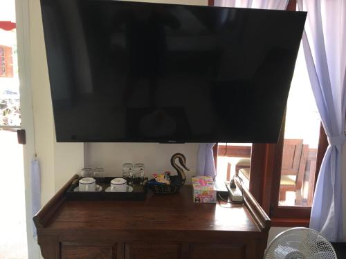 a flat screen tv on top of a wooden table at Naraya Homestay in San Pa Tong