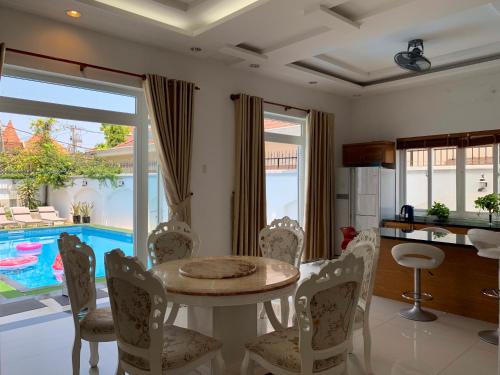 a dining room with a table and chairs and a pool at Nancy Vung Tau in Vung Tau