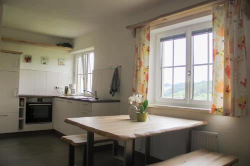 a kitchen with a wooden table and a window at Ferienwohnungen Schöbringer in Weyregg