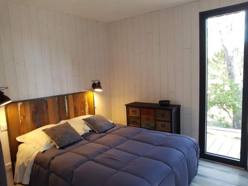 Un dormitorio con una cama grande con cabecero de madera. en Sous les pins, en Nages-et-Solorgues