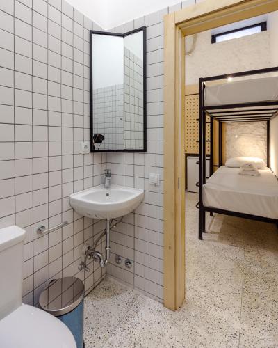 a bathroom with a sink and a bed with a mirror at Back2ME in Batumi