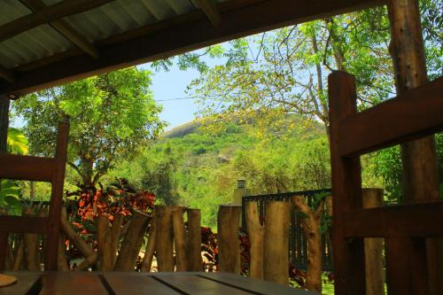 a view from a wooden fence looking out at a mountain at Thal Sewana in Sigiriya