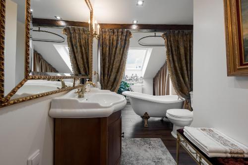 a bathroom with a sink and a tub and a toilet at Grand Duke Apartments in Vilnius